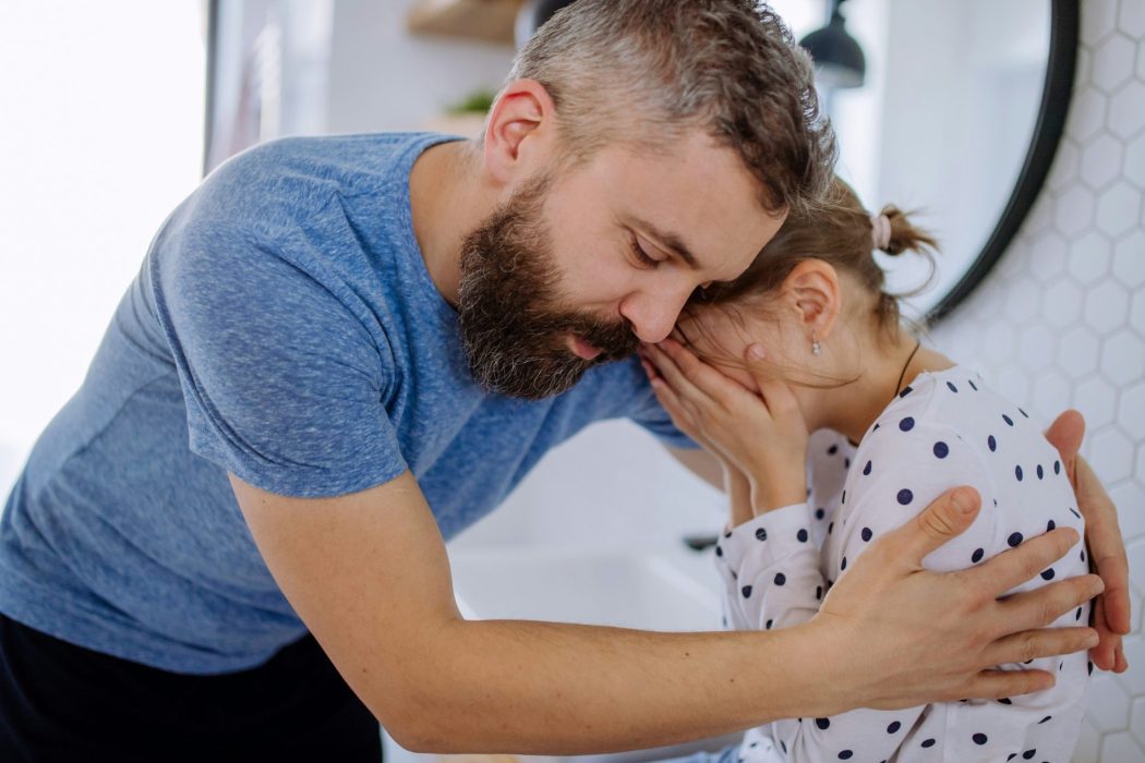 Father gently comforting his daughter during a moment of big emotions in children, showing calm support and connection.