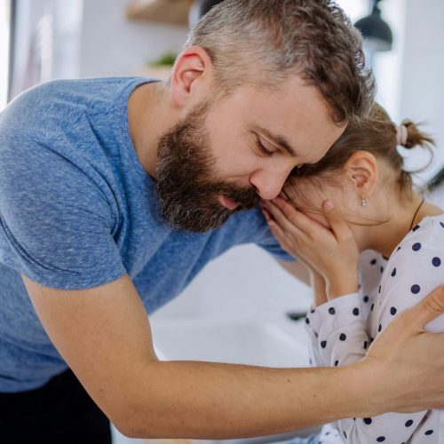 Father gently comforting his daughter during a moment of big emotions in children, showing calm support and connection.