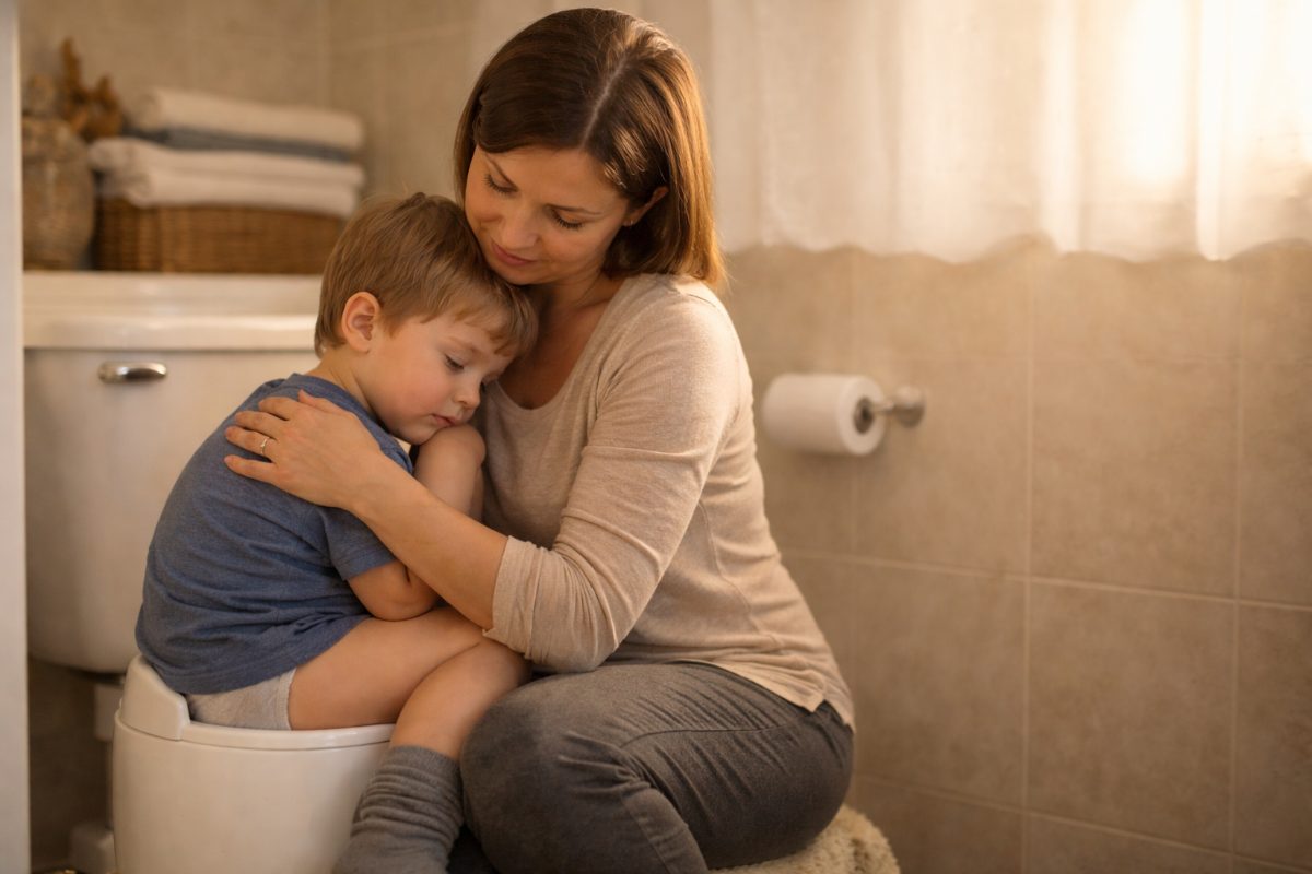 Parent gently comforting a young child sitting on a potty in a calm bathroom setting natural remedies constipation in children