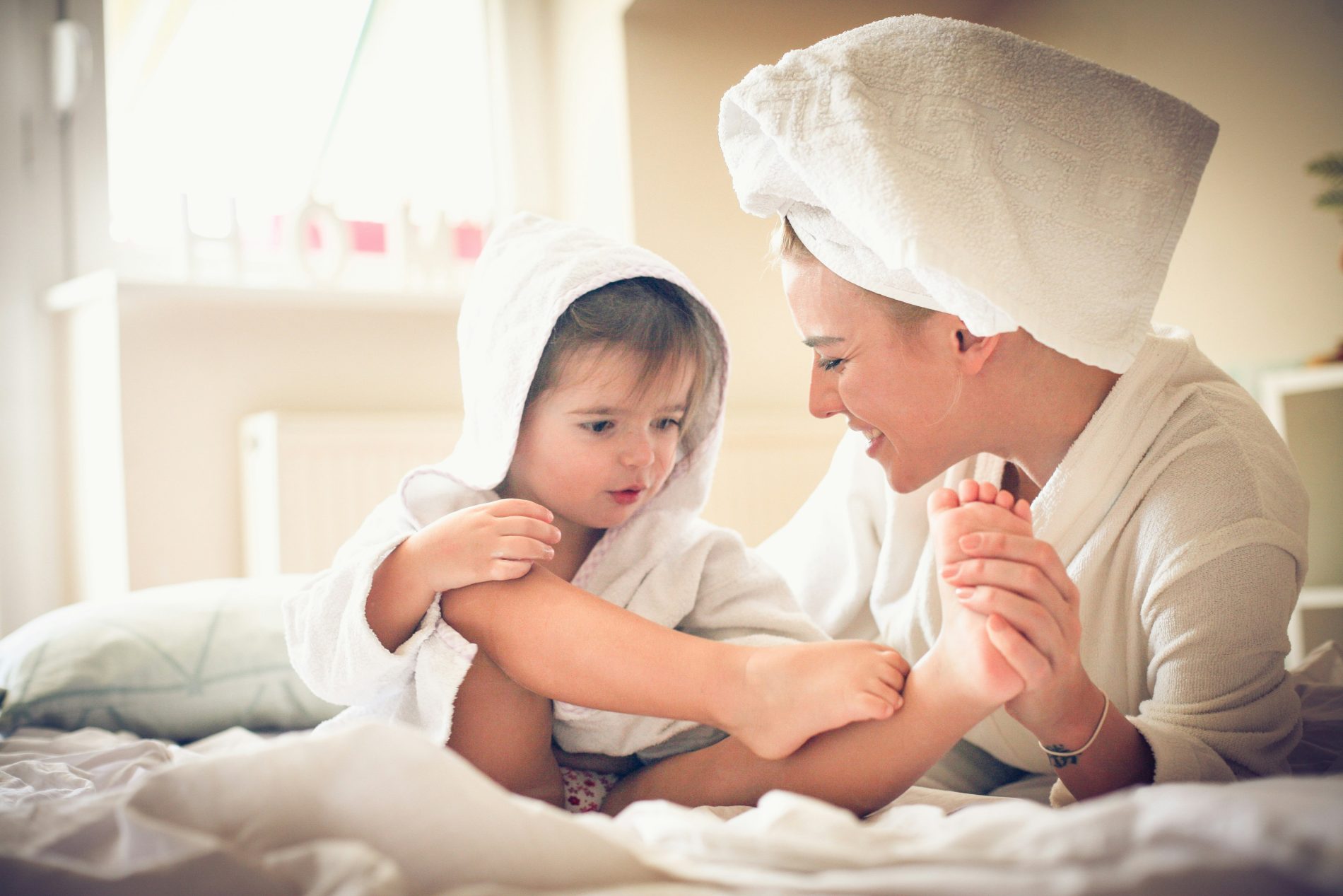 Parent gently massaging a child’s foot to calm the body and ease bedtime resistance in children.