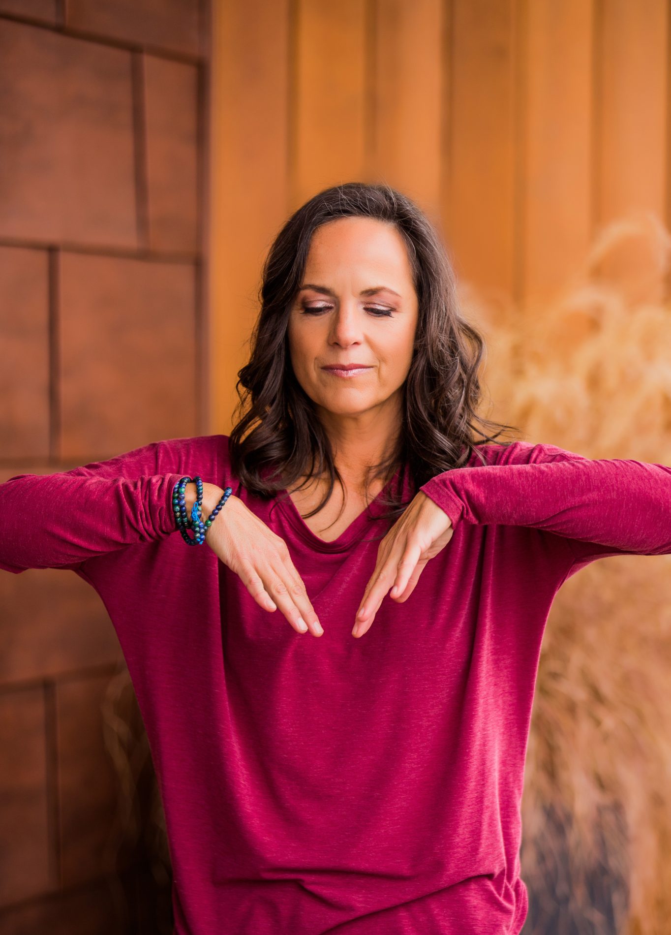 Woman practicing a standing Qigong Healing Sounds movement while using focused breath and sound.