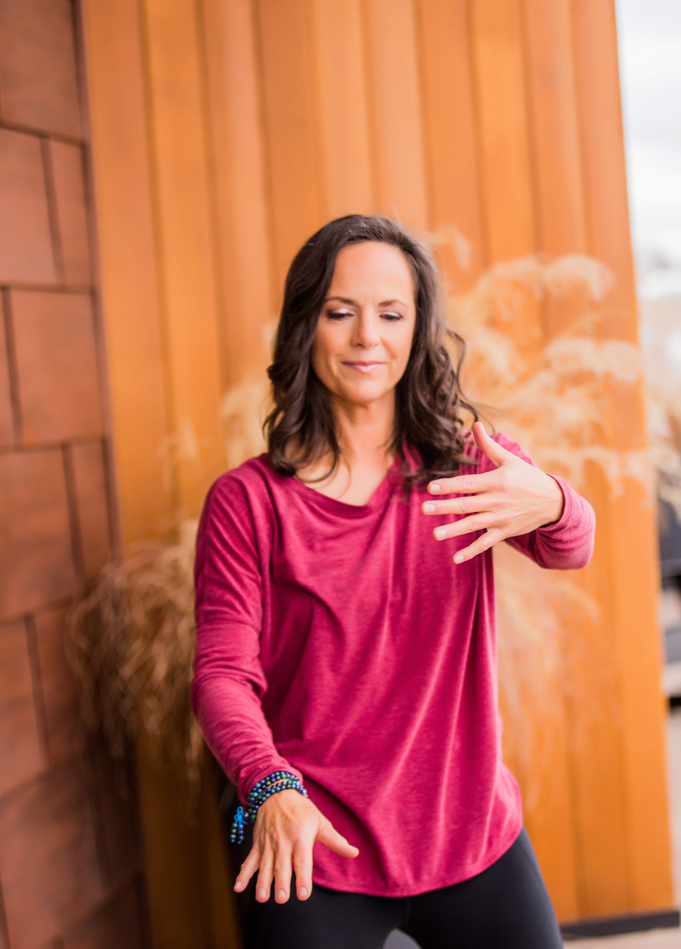 Woman practicing qigong in a serene setting hands moving through the water imagery.